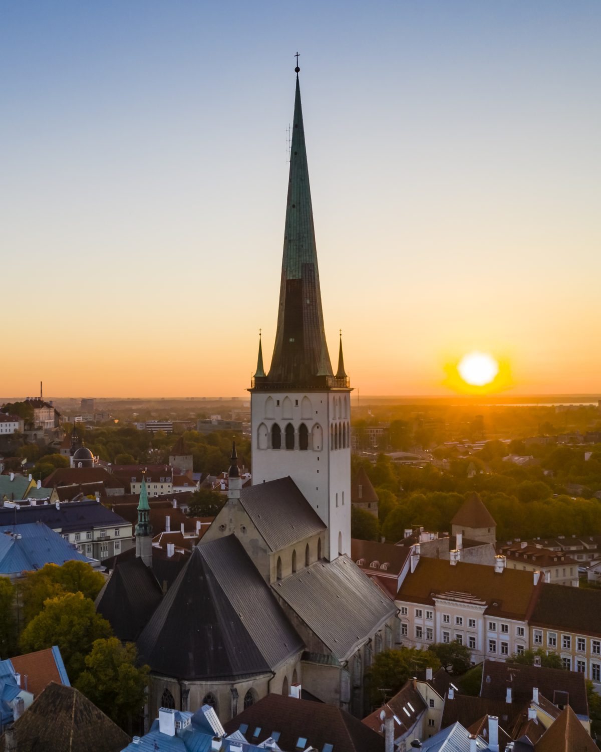 Tallinn Old Town at sunset, St Olaf&rsquo;s spire against the low sun