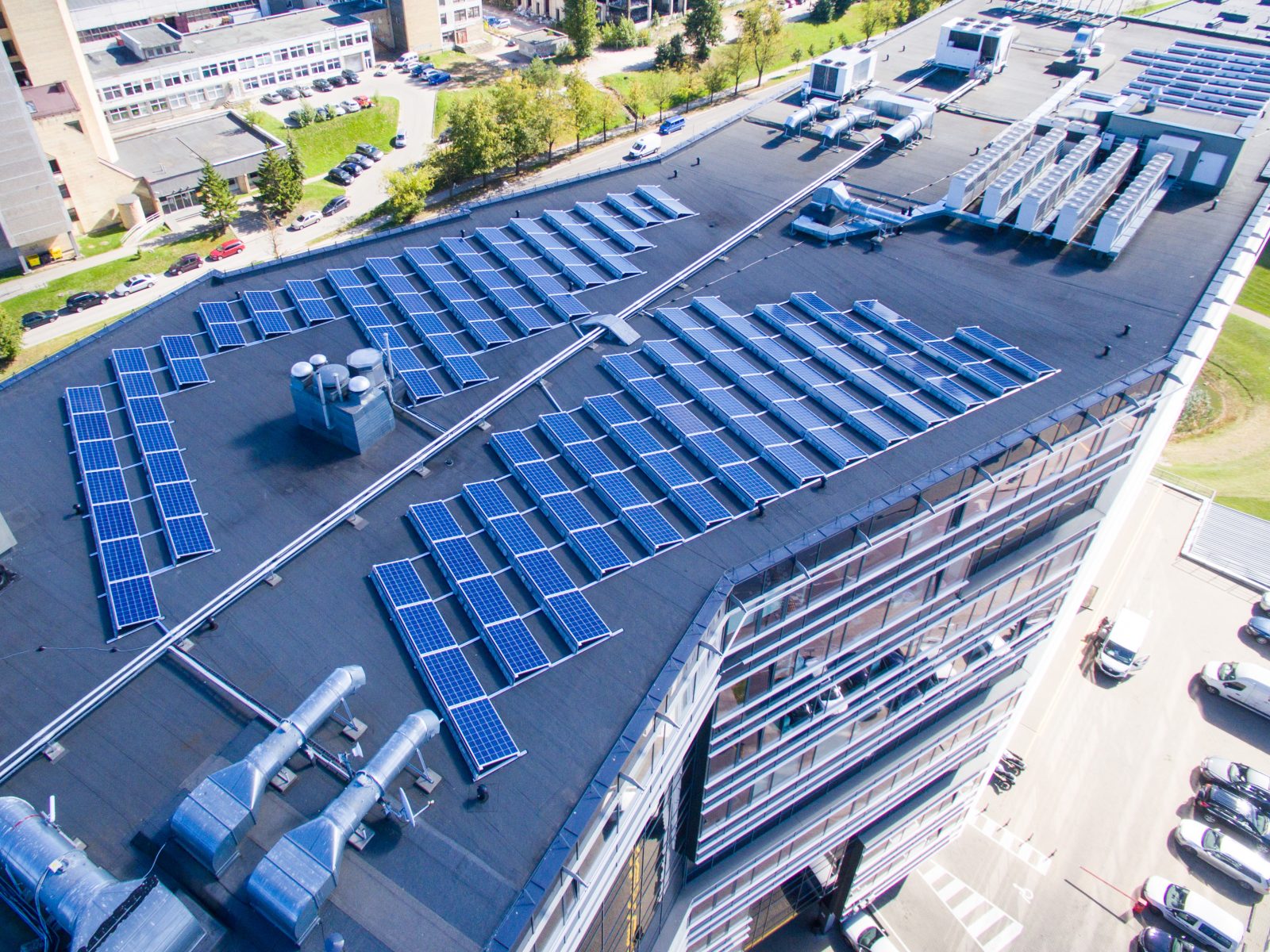 Rows of solar panels on the flat roof of an office building